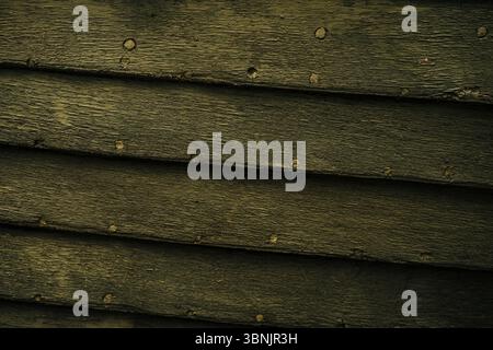 A close up view of aged wooden planks, showcasing a rustic, textured surface. The wood grain and natural imperfections give the backdrop a warm, vinta Stock Photo