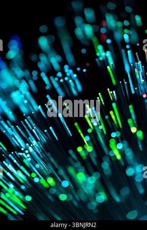 A stunning display of glowing optical fibers against a dark backdrop. The colorful lights illustrate the flow of data and technology, symbolizing mode Stock Photo