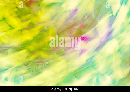 Abstract image featuring dynamic swirls of vibrant greens, yellows, and purples, capturing a sense of movement and energy. The interplay of colors sug Stock Photo