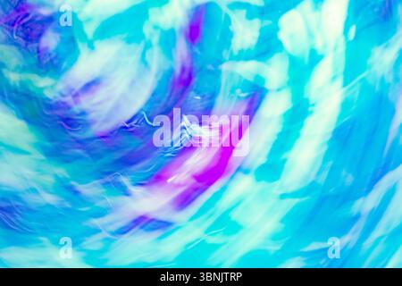 A dynamic abstract image showcasing swirling blue, purple, and white hues, capturing the essence of chromadynamics. The vibrant waves create a mesmeri Stock Photo