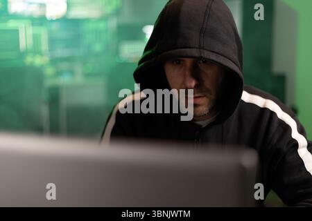 Hacker breaking into a secure network in a dark room Stock Photo