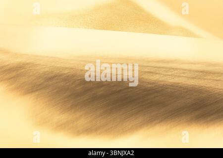 A mesmerizing view of golden sand dunes with intricate textures, capturing the essence of the desert landscape. The subtle patterns and shades create Stock Photo