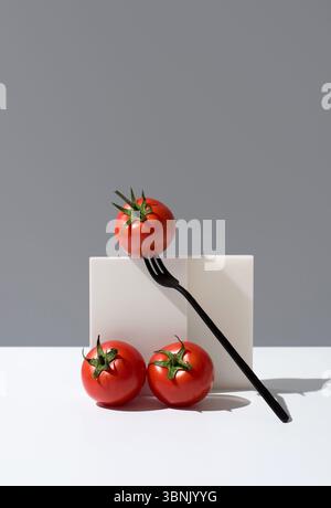 Three bright red, ripe tomatoes are elegantly displayed on a simple, minimalist background. The composition highlights their fresh, juicy texture and Stock Photo