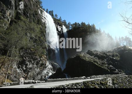 Norway - 19th April 2025 - Image of Hesjedalsfossen waterfall with sun rays shining through water spray on a sunny afternoon Stock Photo