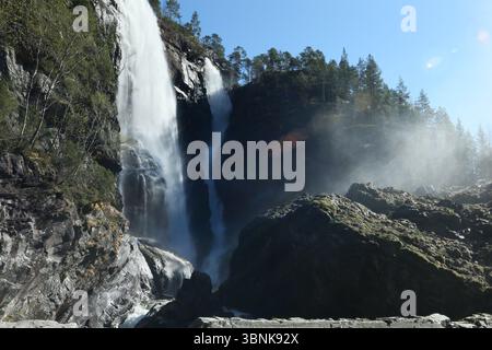 Norway - 19th April 2025 - Image of Hesjedalsfossen waterfall with sun rays shining through water spray on a sunny afternoon Stock Photo