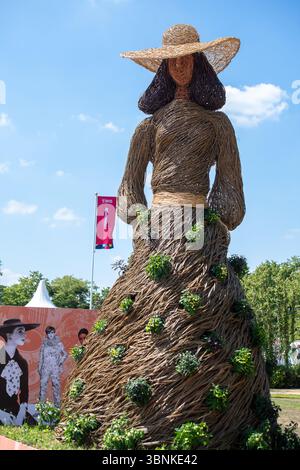 East Molesey, Surrey, UK. 30th June, 2025. A wicker Jane Austen figure at the RHS Hampton Court Palace Garden Festival 2025 made by Environmental Artists Rebecca & Mark Ford celebrating 60 years of fashion in Kingston. Contemporary artists Mark Antony Haden Ford and Rebecca Ford of Two Circles Design work with natural materials.  Working at their studio in Slindon, within the South Downs National Park, making for both public and private sectors. Both have a strong interest in the archaeology, geography and wonders of the natural world, drawing on traditions and techniques of willow craft and w Stock Photo