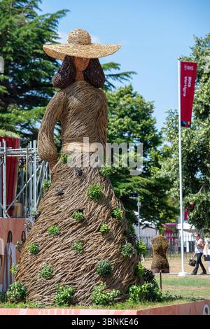 East Molesey, Surrey, UK. 30th June, 2025. A wicker Jane Austen figure at the RHS Hampton Court Palace Garden Festival 2025 made by Environmental Artists Rebecca & Mark Ford celebrating 60 years of fashion in Kingston. Contemporary artists Mark Antony Haden Ford and Rebecca Ford of Two Circles Design work with natural materials.  Working at their studio in Slindon, within the South Downs National Park, making for both public and private sectors. Both have a strong interest in the archaeology, geography and wonders of the natural world, drawing on traditions and techniques of willow craft and w Stock Photo