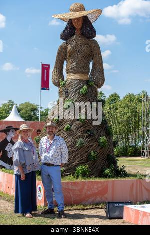 East Molesey, Surrey, UK. 30th June, 2025. A wicker Jane Austen figure at the RHS Hampton Court Palace Garden Festival 2025 made by Environmental Artists Rebecca & Mark Ford (pictured) celebrating 60 years of fashion in Kingston. Contemporary artists Mark Antony Haden Ford and Rebecca Ford of Two Circles Design work with natural materials.  Working at their studio in Slindon, within the South Downs National Park, making for both public and private sectors. Both have a strong interest in the archaeology, geography and wonders of the natural world, drawing on traditions and techniques of willow Stock Photo