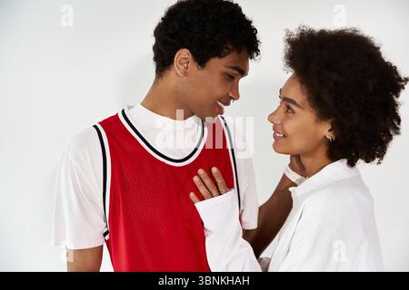 Two young individuals express their affection in a modern, bright space, radiating happiness. Stock Photo