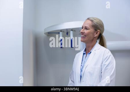 Panoramic dental X-ray machine is hanging on light grey wall with blue handles in dental clinic Stock Photo