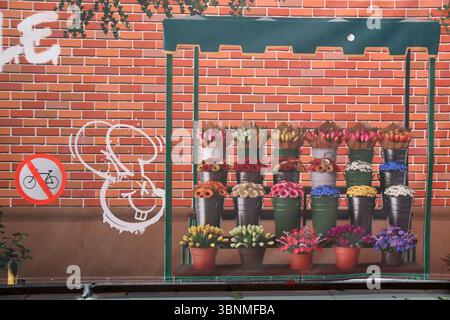 Bucket of cut flowers for sale at market stall in front of brick wall as a painted picture Stock Photo