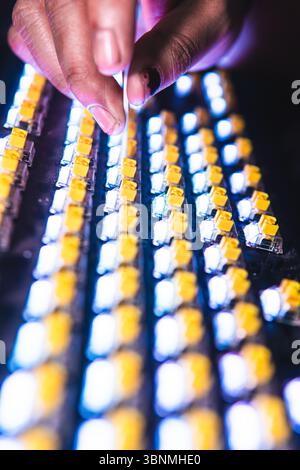 Close-up of a person cleaning yellow mechanical keyboard switches using a cotton bud. Stock Photo