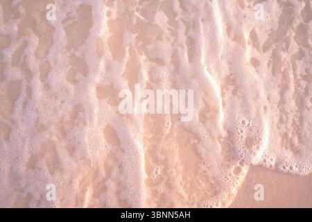 Detailed Beach texture with foaming sea water along shore over sand Stock Photo