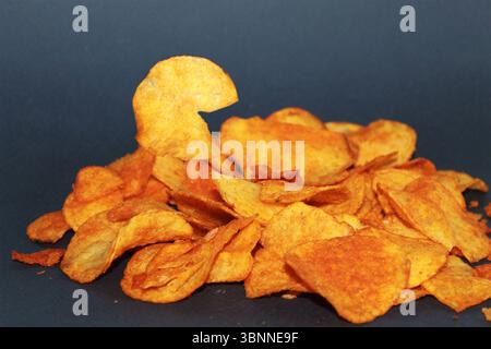 Chips with paprika on a dark background. Stock Photo