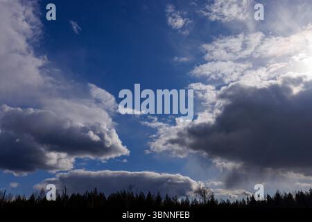 Dark gray rain clouds and clear blue sky , Finland Stock Photo