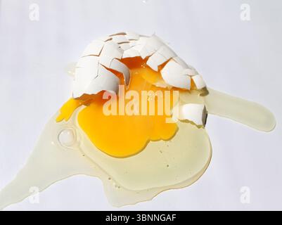 Broken chicken egg on white background. Top view. Stock Photo