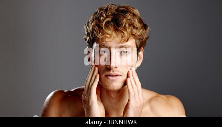 Man, beauty and facial hair in portrait for skincare, grooming and dermatology on a grey background. Redhead, self care and male model serious with Stock Photo