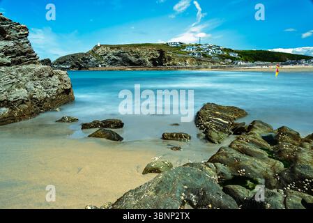 A long exposure photograph captures the serene beauty of a coastal scene. The blurred water contrasts with the sharp details of the rocks and Stock Photo