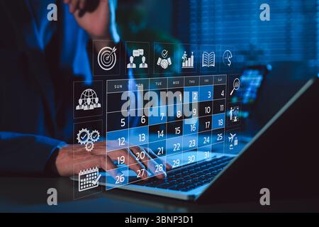 Time management and calendar planning concept. A person using laptop with digital monthly calendar, representing time management, event planning, Stock Photo