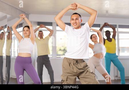 Young Asian male instructor leading modern dance class Stock Photo