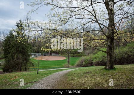 Baseball field in Mowry Park, Pittsburgh, Pennsylvania, on a cloudy spring day, surrounded by trees with new blossoms. Stock Photo