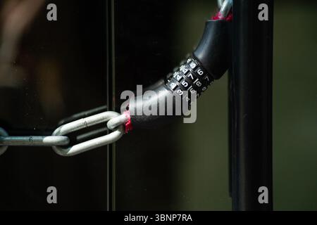Metal chain secured by a modern combination lock. Concept of security, privacy, and asset protection. Stock Photo