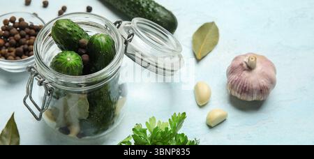 Jar with fresh cucumbers for preservation on light blue background, closeup Stock Photo