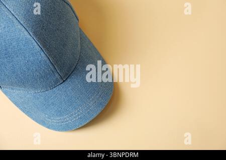 Denim baseball hat on beige background, top view. Space for text Stock Photo