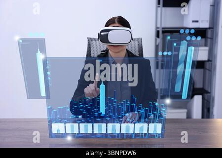 Building information modelling. Woman using virtual reality headset in office. Holographic screen with cityscape Stock Photo