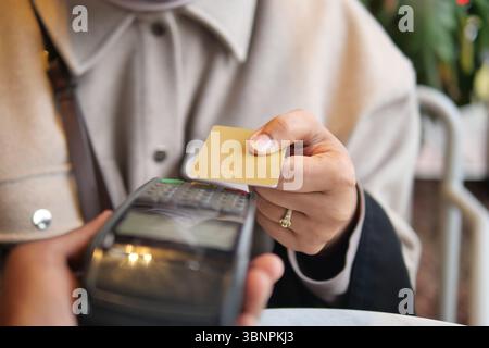 Person making a contactless payment at a cafe Stock Photo