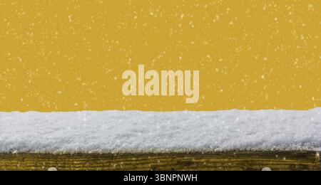 Empty wooden table snow covered with snowfall isolated on Fortuna Gold color background Stock Photo