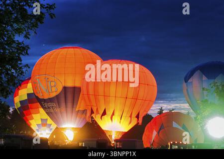Multiple Hot Air Balloon Glow as Balloons Fire There Propane Tanks and Light Up the Balloons on a Summer Evening Stock Photo