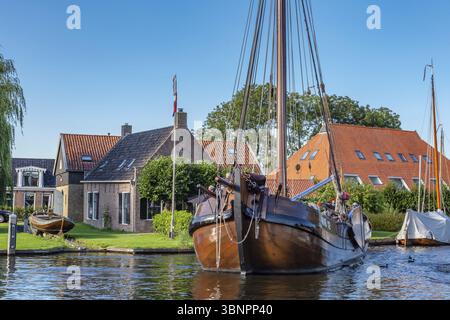 Heeg, Netherlands - August 05, 2020: Tjalk sailing boat leaving for a trip from water recreation village Heeg in Friesland in the Netherlands Stock Photo