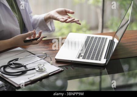 Close up Female doctor talking on video call through laptop at clinic Stock Photo