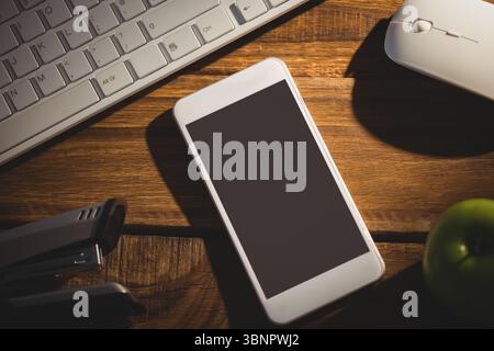 Flat design is showing white smartphone resting on desk with keyboard, mouse, power banks and apple Stock Photo