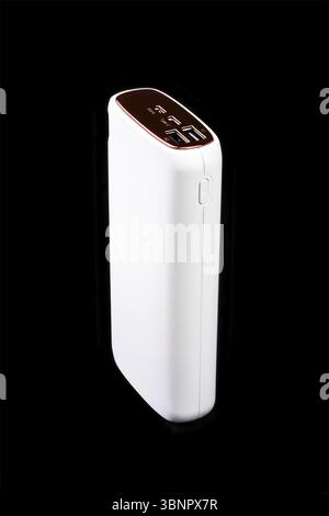 White power bank for charging smartphones and various digital devices on a black background close-up Stock Photo