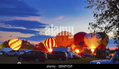 Multiple Hot Air Balloon Glow as Balloons Fire There Propane Tanks and Light Up the Balloons on a Summer Evening Stock Photo