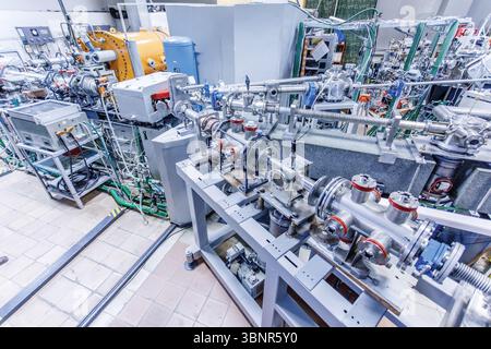 Wide view of hadron collider lab with particle accelerator system and experimental devices for quantum physics research Stock Photo