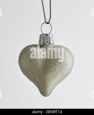 Green heart shaped Christmas ball with hanging loop isolated nature background with clipping path Stock Photo