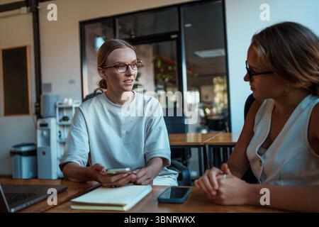 Two Women Engaging in a Highly Productive and Insightful Office Conversation Together Stock Photo