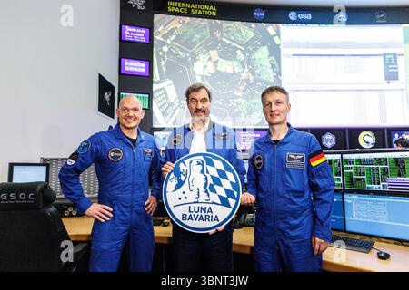04 July 2025, Bavaria, Oberpfaffenhofen: Markus Söder (CSU), party leader and Minister President of Bavaria, stands between Alexander Gerst, German geophysicist, volcanologist and astronaut, and Matthias Josef Maurer, German materials scientist and ESA astronaut, holding a sign reading "Luna Bavaria" at the Bavarian Moon Summit in the German Space Operations Center (GSOC) at the German Aerospace Center (DLR) in Oberpfaffenhofen near Munich (Bavaria) in the mission control rooms of the Columbus Control Center. The German Space Operations Center (GSOC) is the Mission Control Center. Topics at th Stock Photo