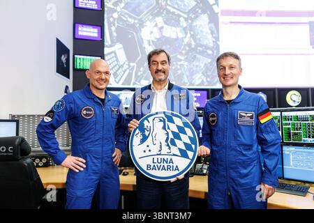 04 July 2025, Bavaria, Oberpfaffenhofen: Markus Söder (CSU), party leader and Minister President of Bavaria, stands between Alexander Gerst, German geophysicist, volcanologist and astronaut, and Matthias Josef Maurer, German materials scientist and ESA astronaut, holding a sign reading "Luna Bavaria" at the Bavarian Moon Summit in the German Space Operations Center (GSOC) at the German Aerospace Center (DLR) in Oberpfaffenhofen near Munich (Bavaria) in the mission control rooms of the Columbus Control Center. The German Space Operations Center (GSOC) is the Mission Control Center. Topics at th Stock Photo