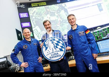 04 July 2025, Bavaria, Oberpfaffenhofen: Markus Söder (CSU), party leader and Minister President of Bavaria, stands between Alexander Gerst, German geophysicist, volcanologist and astronaut, and Matthias Josef Maurer, German materials scientist and ESA astronaut, holding a sign reading "Luna Bavaria" at the Bavarian Moon Summit in the German Space Operations Center (GSOC) at the German Aerospace Center (DLR) in Oberpfaffenhofen near Munich (Bavaria) in the mission control rooms of the Columbus Control Center. The German Space Operations Center (GSOC) is the Mission Control Center. Topics at th Stock Photo