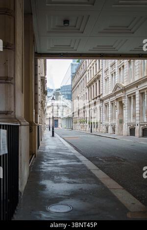 United Kingdom, London, 14 Jul 2025. Quiet narrow alley in the City of London, showing classic architecture and wet pavement after rain Stock Photo
