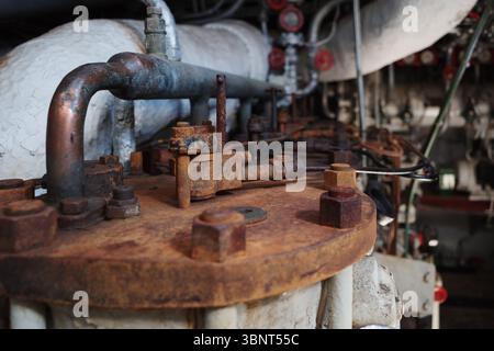 A detailed close-up of old and rusty industrial machinery, likely from a factory or an engine room. Stock Photo