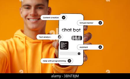 Young man showcasing a chatbot interface on a smartphone against a bright orange background Stock Photo