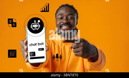 Man showcasing chatbot app on smartphone while standing against vibrant orange background Stock Photo