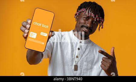 Man showcasing chatbot application on mobile device against vibrant orange backdrop Stock Photo