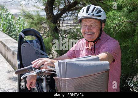 Elderly Man in a Bike Helmet Resting After a Ride Stock Photo