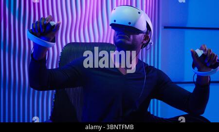African American man guy male gamer gaming vr play wearing virtual reality glasses helmet three dimension game modern cyber technology neon futurism Stock Photo